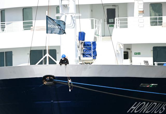 A crew member assists the docking as the Dutch Hantavirus-hit cruise ship MV Hondius arrives at the port of Rotterdam on May 18, 2026. Cruise ship MV Hondius is expected to arrive at the port of Rotterdam and the ship's crew members will undergo a medical screening. (Photo by NICOLAS TUCAT / AFP)