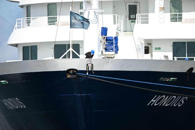 A crew member assists the docking as the Dutch Hantavirus-hit cruise ship MV Hondius arrives at the port of Rotterdam on May 18, 2026. Cruise ship MV Hondius is expected to arrive at the port of Rotterdam and the ship's crew members will undergo a medical screening. (Photo by NICOLAS TUCAT / AFP)