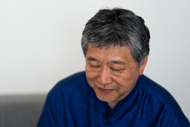 Japanese director and screenwriter Hirokazu Kore-eda looks down during an interview on the sidelines of the 79th edition of the Cannes Film Festival in Cannes, southern France, on May 17, 2026. Hirokazu Kore-eda, a leading figure in Japanese cinema and winner of the 2018 Palme d’Or, said on May 17, 2026 in Cannes – where his new film "Sheep in the Box" is in competition – that he would fight “to the very end” to ensure that a human being is involved “at every stage of film production”. (Photo by Julie SEBADELHA / AFP)