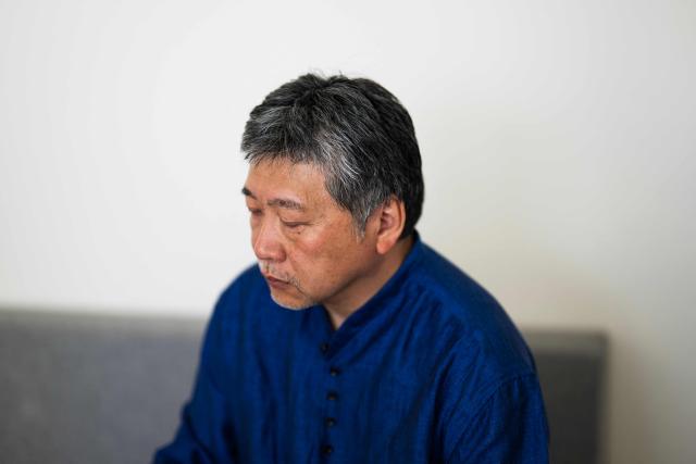 Japanese director and screenwriter Hirokazu Kore-eda looks down during an interview on the sidelines of the 79th edition of the Cannes Film Festival in Cannes, southern France, on May 17, 2026. Hirokazu Kore-eda, a leading figure in Japanese cinema and winner of the 2018 Palme d’Or, said on May 17, 2026 in Cannes – where his new film "Sheep in the Box" is in competition – that he would fight “to the very end” to ensure that a human being is involved “at every stage of film production”. (Photo by Julie SEBADELHA / AFP)