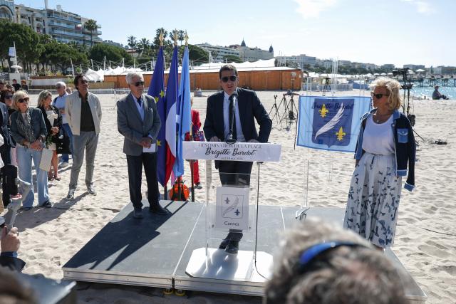 Mayor of Cannes David Lisnard (C) delivers a speech next to German media executive and President of the Cannes Film Festival Iris Knobloch (R) during a ceremony to rename Plage Mace "Brigitte Bardot Beach" on the sidelines of the 79th edition of the Cannes Film Festival in Cannes, southern France, on May 18, 2026. (Photo by Sameer AL-DOUMY / AFP)