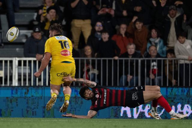TOPSHOT - La Rochelle's French hooker Quentin Lespiaucq (L) runs with the ball during the French Top 14 rugby union match between Stade Rochelais and Stade Toulousain at the Marcel-Deflandre Stadium in La Rochelle, western France, on May 17, 2026. (Photo by XAVIER LEOTY / AFP)