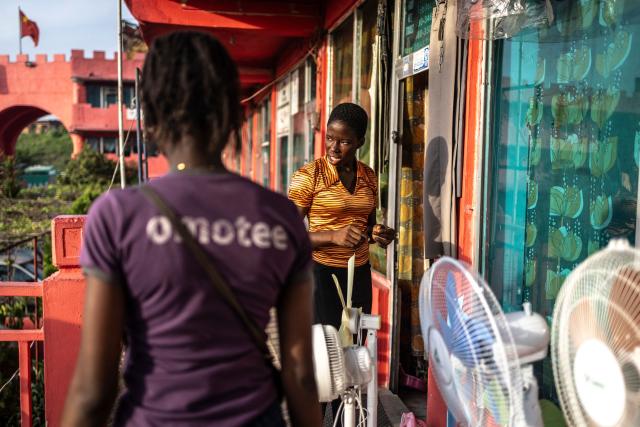 A vendor speaks with customers at China Town in the Ojota neighbourhood of Lagos on May 4, 2026. (Photo by OLYMPIA DE MAISMONT / AFP)