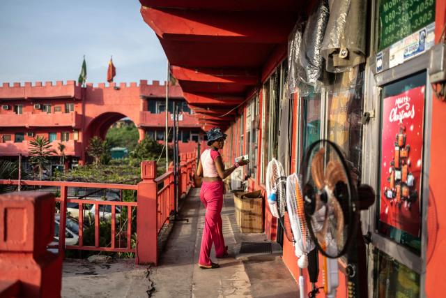 A vendor looks on as she enters a shop at China Town in the Ojota neighbourhood of Lagos on May 4, 2026. (Photo by OLYMPIA DE MAISMONT / AFP)