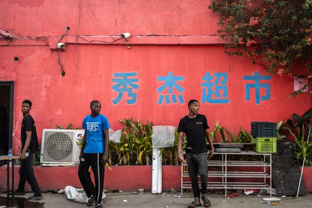 TOPSHOT - Workers stand outside a supermarket at China Town in the Ojota neighbourhood of Lagos on May 4, 2026. (Photo by OLYMPIA DE MAISMONT / AFP)