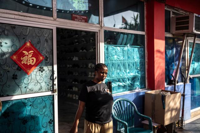 TOPSHOT - A vendor looks on as she walks out a shop inside China Town in the Ojota neighbourhood of Lagos on May 5, 2026. (Photo by OLYMPIA DE MAISMONT / AFP)