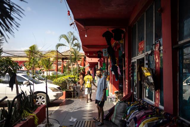 A shop owner looks on as he stands outside his store at China Town in the Ojota neighbourhood of Lagos on May 5, 2026. (Photo by OLYMPIA DE MAISMONT / AFP)