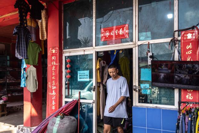 A shop owner steps out of his store at China Town in the Ojota, Lagos, on May 5, 2026. (Photo by OLYMPIA DE MAISMONT / AFP)