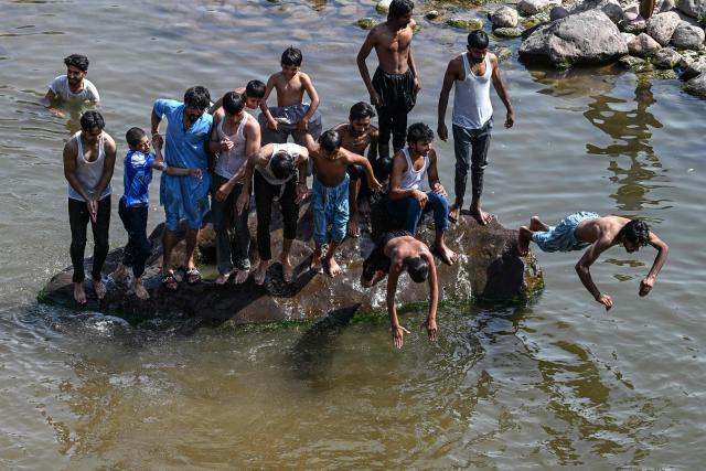 Youths cool off in stream water near Rawal Dam during a hot summer afternoon in Islamabad on May 18, 2026. (Photo by Aamir QURESHI / AFP)
