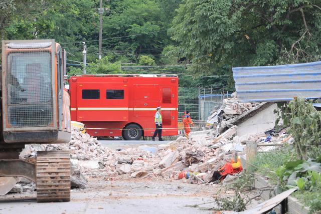 First responders are seen outside a collapsed building after an earthquake at Liunan district, in Liuzhou, China's southern Guangxi region on May 18, 2026. A 5.2-magnitude earthquake struck south China's Guangxi region on May 18, killing two people and causing 13 buildings to collapse, state media reported. (Photo by CN-STR / AFP) / China OUT