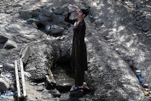 A man pours water over his face to cool off in a stream near Rawal Dam during a hot summer afternoon in Islamabad on May 18, 2026. (Photo by Aamir QURESHI / AFP)