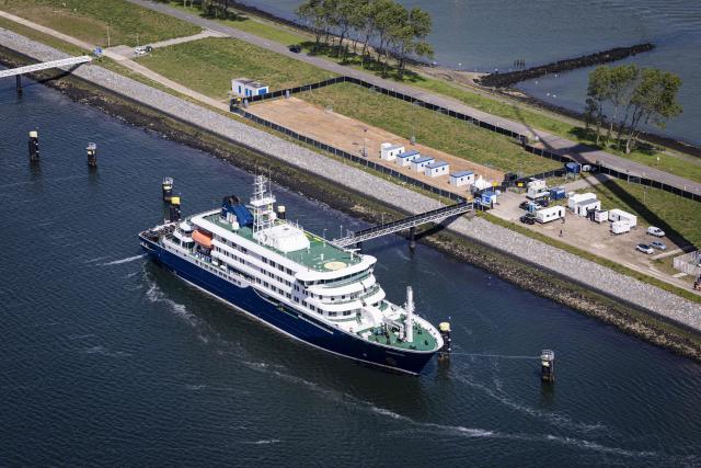 This aerial view shows he Dutch Hantavirus-hit cruise ship MV Hondius docked at the port of Rotterdam on May 18, 2026. A cruise ship that sparked global alarm after a deadly outbreak of hantavirus docked in Rotterdam harbour on May 18, with the skeleton crew facing weeks of quarantine. (Photo by Robin VAN LONKHUIJSEN / ANP / AFP) / Netherlands OUT