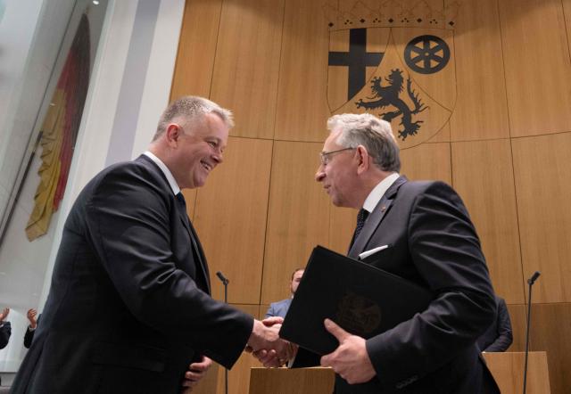 The new State Premier of Rhineland-Pfalz, member of the conservative Christian Democratic Union (CDU) party Gordon Schnieder (L) is congratulated by the President of the State Parliament Matthias Lammert after a sworn in ceremony on May 18, 2026 in Mainz, western Germany. The Constituent session of the new state parliament with the election of the Minister-President of Rhineland-Palatinate follows the state elections of March 22, 2026. (Photo by Boris Roessler / POOL / AFP)