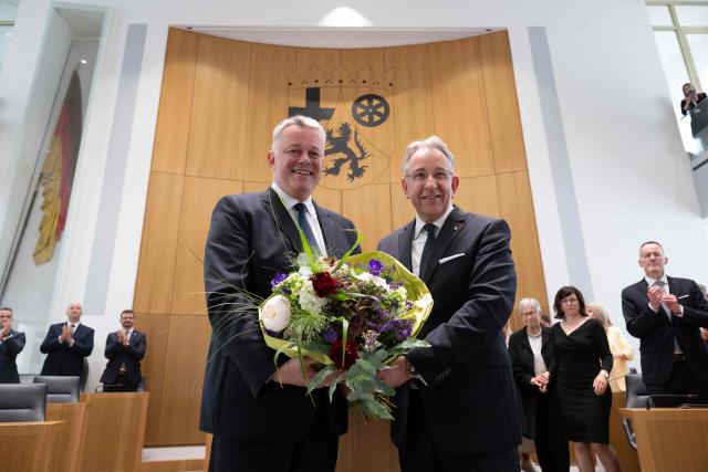 The new State Premier of Rhineland-Pfalz, Gordon Schnieder (L) and the President of the State Parliament Matthias Lammert, pose for medias with a bouquet of flowers after a sworn-in ceremony on May 18, 2026 in Mainz, western Germany. The Constituent session of the new state parliament with the election of the Minister-President of Rhineland-Palatinate follows the state elections of March 22, 2026. (Photo by Boris Roessler / dpa Pool / AFP)