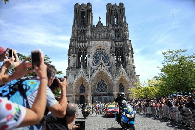(FILES) Cyclists ride past the Cathedral of Notre-Dame of Reims at the start of the fourth stage of the 106th edition of the Tour de France cycling race between Reims and Nancy, in Reims, eastern France, on July 9, 2019. The Tour de France 2028 will start in Reims announced Amaury Sport Organisation (ASO) on May 18, 2026. (Photo by Anne-Christine POUJOULAT / AFP)