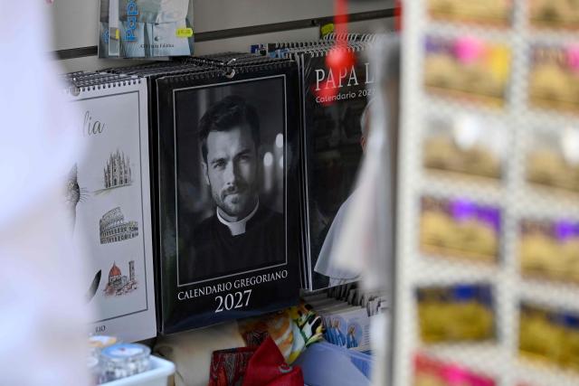 Calendars displaying pictures of models dressed as priests are on sale in souvenirs shops, in Rome on May 18, 2026. (Photo by Andreas SOLARO / AFP)