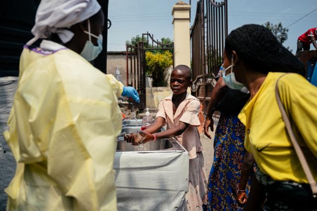 A young girl washes her hands before entering Kyeshero Hospital at a checkpoint for hand washing and temperature screening for all visitors and patients entering Kyeshero Hospital, as part of Ebola prevention measures in Goma on May 18, 2026. A first case of Ebola virus infection has been reported in Goma, a major city in eastern Democratic Republic of Congo controlled by the M23 armed group, with the WHO declaring an international health alert on May 17, 2026. (Photo by Jospin Mwisha / AFP)