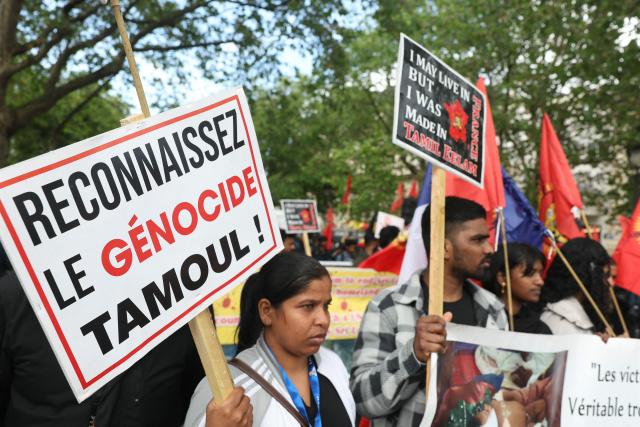 A member (L) of the Tamil community in France holds a placard reading “Recognize the Tamil genocide” during a protest march in Paris on May 18, 2026, demanding that Sri Lanka recognize what they describe as the Tamil genocide. (Photo by Alain JOCARD / AFP)