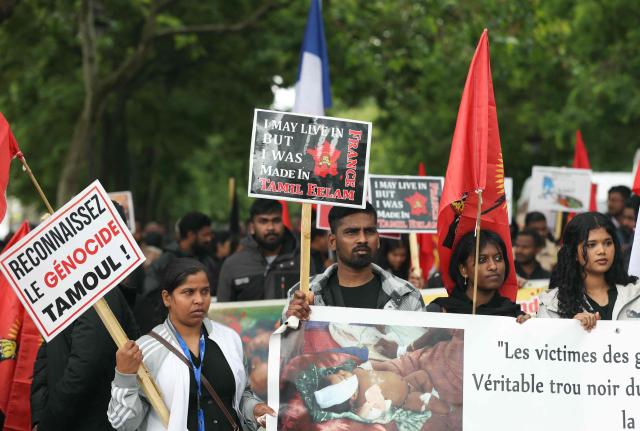 A member (L) of the Tamil community in France holds a placard reading “Recognize the Tamil genocide” during a protest march in Paris on May 18, 2026, demanding that Sri Lanka recognize what they describe as the Tamil genocide. (Photo by Alain JOCARD / AFP)