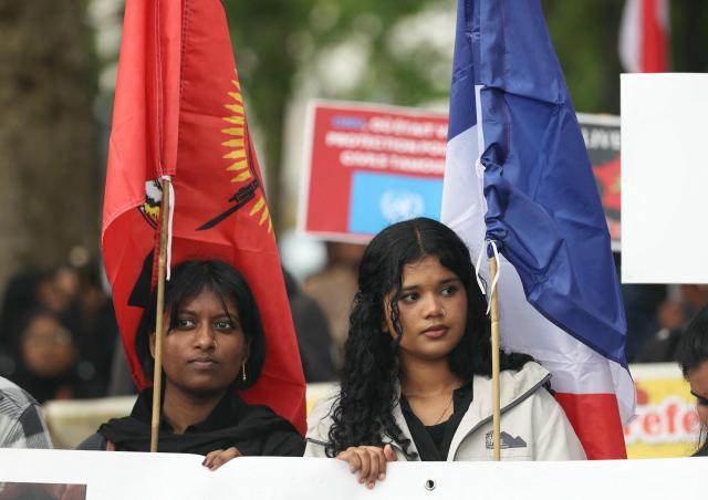 Members of the Tamil community in France holding the Tamil Tiger flag (L) and the French flag (R) take part in a protest march in Paris on May 18, 2026, demanding that Sri Lanka recognize what they describe as the Tamil genocide. (Photo by Alain JOCARD / AFP)