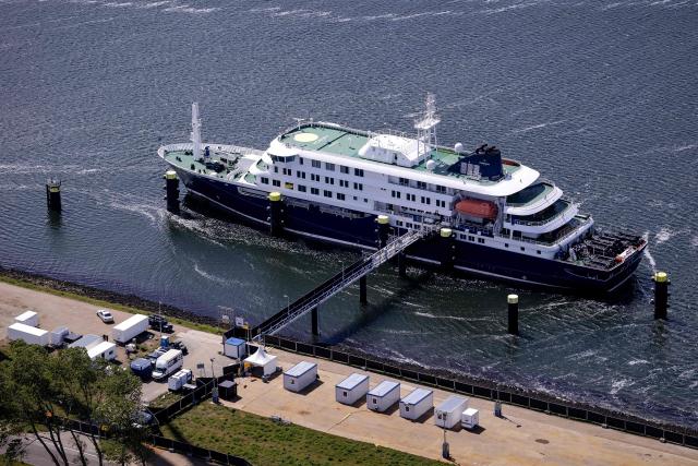 This aerial view shows the Dutch Hantavirus-hit cruise ship MV Hondius docked after arriving at the port of Rotterdam on May 18, 2026. A cruise ship that sparked global alarm after a deadly outbreak of hantavirus docked in Rotterdam harbour on May 18, with the skeleton crew facing weeks of quarantine. (Photo by Peter Lipton / ANP / AFP) / Netherlands OUT