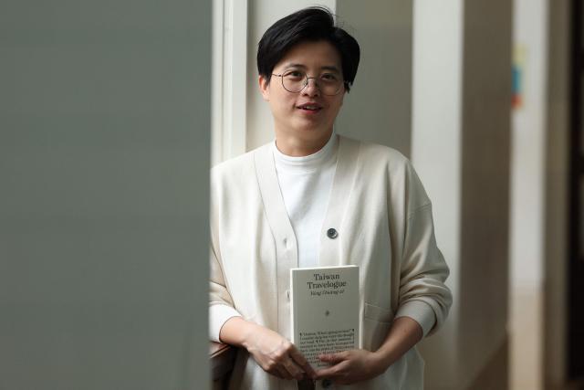 Taiwanese writer Yang Shuang-zi poses with her book "Taiwan Travelogue" during an appearance at SOAS in central London on May 18, 2026, on the eve of the 2026 International Booker Prize announcement. Yang Shuang-zi's "Taiwan Travelogue" is one of the six International Booker Prize entries for 2026 (Photo by Adrian Dennis / AFP)
