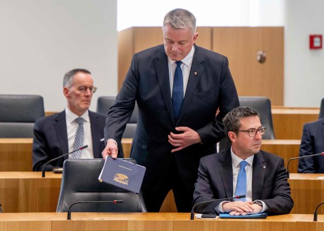 The new State Premier of Rhineland-Palatinate, member of the conservative Christian Democratic Union (CDU) party, Gordon Schnieder (C), returns to his seat after delivering his first speech at the State Parliament on May 18, 2026 in Mainz, western Germany, as Marcus Klein, Minister for Federal and European Affairs, Sport, Media and Volunteering and Head of the State Chancellery, looks right (R). The Constituent session of the new state parliament with the election of the Minister-President of Rhineland-Palatinate follows the state elections of March 22, 2026. (Photo by Torsten Silz / AFP)