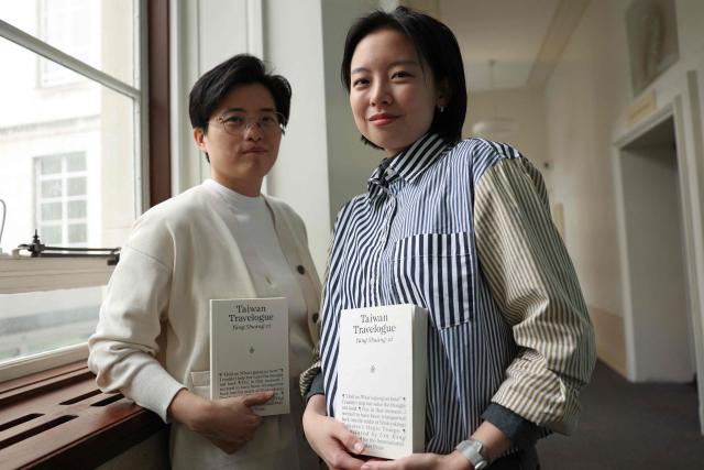 Taiwanese writer Yang Shuang-zi (L) poses with her book "Taiwan Travelogue" beside her translator Lin King (R) during an appearance at SOAS in central London on May 18, 2026, on the eve of the 2026 International Booker Prize announcement. Yang Shuang-zi's "Taiwan Travelogue" is one of the six International Booker Prize entries for 2026 (Photo by Adrian DENNIS / AFP)