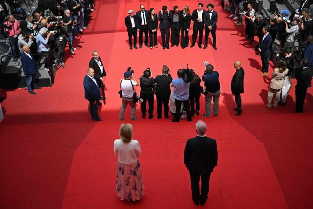 Photographers take pictures of the cast as they arrive for the screening of the film "L'Inconnue" (The Unknown) at the 79th edition of the Cannes Film Festival in Cannes, southern France on May 18, 2026. (Photo by Antonin THUILLIER / AFP)