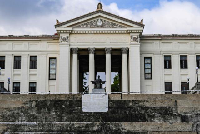 A “No Sitting” and “No Entry” sign is visible on the stairs at the University of Havana on May 13, 2026. Since February 2026, the fuel crisis in Cuba—marked by the oil blockade imposed by the United States—has left universities without in-person classes. Today, practical degrees such as architecture and design are surviving amid blackouts, shortages and slashed programmes. Training has become so fragmented that an entire generation fears they are being left professionally half-formed. (Photo by YAMIL LAGE / AFP)