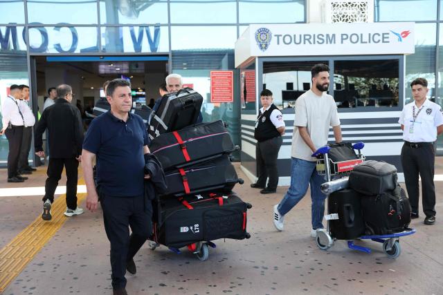 Iran's head coach Amir Ghalenoei (L) exits a terminal following the arrival of Iran's national football team in Turkey ahead of their trip to the United States for the FIFA World Cup 2026, at Antalya airport in Antalya, southern Turkey, on May 18, 2026. Iran's football team arrived in Turkey on Monday for a training camp and to complete visa applications ahead of the 2026 World Cup, AFP correspondents said. (Photo by Oner SAN / AFP)