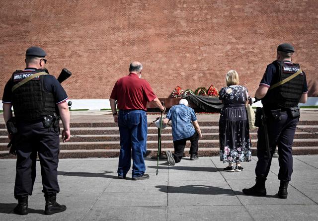 A man kneels in front the Tomb of the Unknown Soldier in downtown Moscow on May 18, 2026. (Photo by Alexander NEMENOV / AFP)