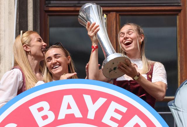 Bayern Munich's players including Bayern Munich's Icelandic defender #04 Glodis Viggosdottir, Bayern Munich's English midfielder #31 Georgia Stanway and Bayern Munich's German forward #17 Klara Buhl celebrate with the trophies on the balcony of the City Hall at Marienplatz in Munich, southern Germany on May 18, 2026. (Photo by Alexandra BEIER / AFP) / ALTERNATIVE CROP