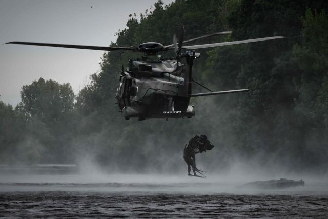 French Foreign Legion combat divers from the 2nd Foreign Parachute Regiment (2e REP) leap from a NH90 Caïman helicopter into the River Vienne during an airborne water insertion exercise in Ingrandes, south-western France, on May 18, 2026. The LIBECCIU 2026 military exercise, running from May 11 to May 20, 2026 across Nouvelle-Aquitaine and Centre-Val de Loire regions, tests short-notice redeployment and interoperability between air and ground components  capabilities central to France's contribution to NATO rapid-reaction forces. (Photo by Philippe LOPEZ / AFP)