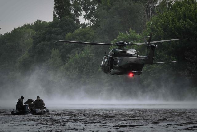 French Foreign Legion combat divers from the 2nd Foreign Parachute Regiment (2e REP) wait on an inflatable boat as a NH90 Caïman helicopter hovers above the River Vienne during a water insertion exercise in Ingrandes, south-western France, on May 18, 2026. The LIBECCIU 2026 military exercise, running from May 11 to May 20, 2026 across Nouvelle-Aquitaine and Centre-Val de Loire regions, tests short-notice redeployment and interoperability between air and ground components  capabilities central to France's contribution to NATO rapid-reaction forces. (Photo by Philippe LOPEZ / AFP)