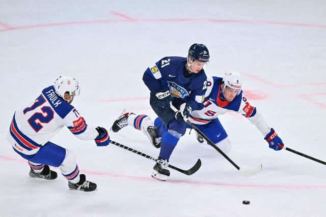 Finland's forward #21 Patrik Puistola (C) fights for the puck with USA's forward #09 Ryan Leonard (R) and USA's defender #72 Justin Faulk (L)  during the IIHF Ice Hockey Men's World Championship first round group A match between Finland and USA at the Swiss Life Arena in Zurich on May 18, 2026. (Photo by SEBASTIEN BOZON / AFP)