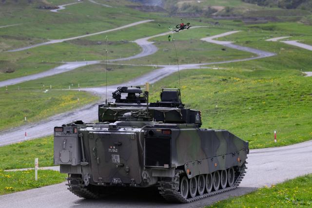 An FPV drone targets a balloon mounted on a tank during a demonstration of procedures for deploying mini-drones in combat situations by the Swiss Army's Drones and Robotics Defence Competence Centre at the Wichlen shooting range near Glarus-Sud on May 18, 2026. (Photo by HAROLD CUNNINGHAM / AFP)
