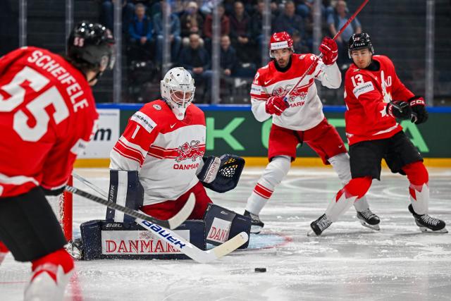 Canada’s forward #55 Mark Scheifele shoota the puck to Denmark's goalkeeper #1 Nicolaj Henriksen during the groupe B match between Canada and Denmark at the IIHF Ice Hockey Men's World Championship at BFC Arena, in Fribourg, Switzerland, on May 18, 2026. (Photo by Fabrice COFFRINI / AFP)