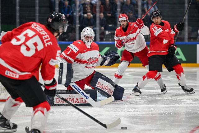Canada’s forward #55 Mark Scheifele fires a shoot to Denmark's goalkeeper #1 Nicolaj Henriksen during the groupe B match between Canada and Denmark at the IIHF Ice Hockey Men's World Championship at BFC Arena, in Fribourg, Switzerland, on May 18, 2026. (Photo by Fabrice COFFRINI / AFP)