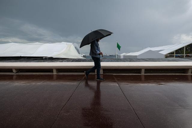 A man walks under an umbrella on the Boulevard de la Croisette on the sidelines of the 79th edition of the Cannes Film Festival in Cannes, southern France, on May 18, 2026. (Photo by SAMEER AL-DOUMY / AFP)