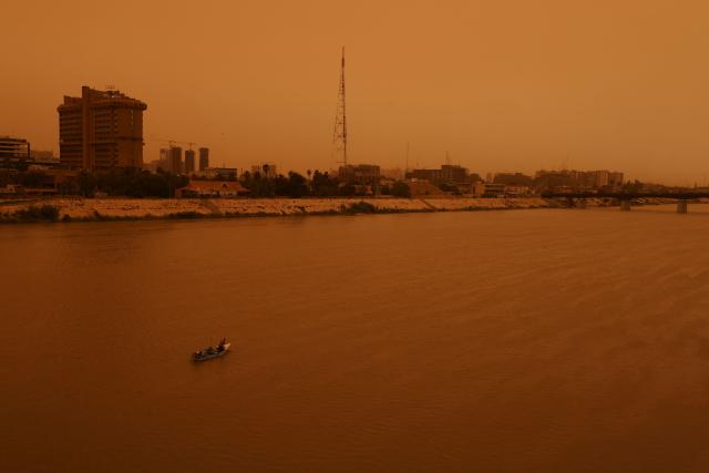 An Iraqi fisherman fishes in the Tigris River in central Baghdad on May 18, 2026, during a dust storm coming from western Iraq. (Photo by AHMAD AL-RUBAYE / AFP)