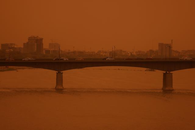 Vehicles travel on the Republic Bridge over the Tigris River in central Baghdad on May 18, 2026, during a dust storm coming from western Iraq. (Photo by AHMAD AL-RUBAYE / AFP)