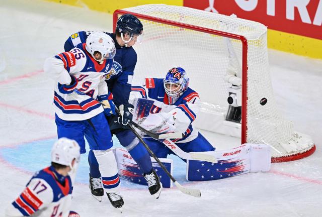 Finland's forward #21 Patrik Puistola (C) fights for the puck with USA's goalkeeper #01 Devin Cooley (R) and USA's defender #55 Ryan Lindgren (L)  during the IIHF Ice Hockey Men's World Championship first round group A match between Finland and USA at the Swiss Life Arena in Zurich on May 18, 2026. (Photo by SEBASTIEN BOZON / AFP)