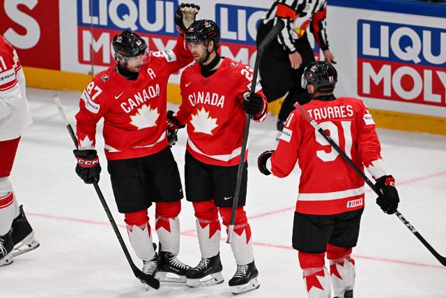 Canada’s defender #29 Parker Wotherspoon celebrates scoring his team's fifth goal with teammates forward #87 Sidney Crosby and forward #91 John Tavares during the groupe B match between Canada and Denmark at the IIHF Ice Hockey Men's World Championship at BFC Arena, in Fribourg, Switzerland, on May 18, 2026. (Photo by Fabrice COFFRINI / AFP)