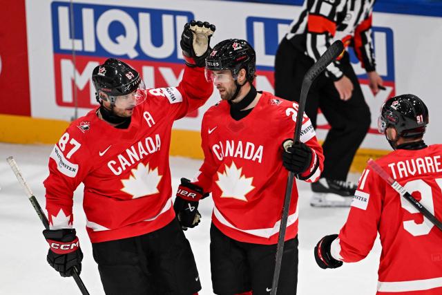 Canada’s defender #29 Parker Wotherspoon celebrates scoring his team's fifth goal with teammates forward #87 Sidney Crosby and forward #91 John Tavares during the groupe B match between Canada and Denmark at the IIHF Ice Hockey Men's World Championship at BFC Arena, in Fribourg, Switzerland, on May 18, 2026. (Photo by Fabrice COFFRINI / AFP)