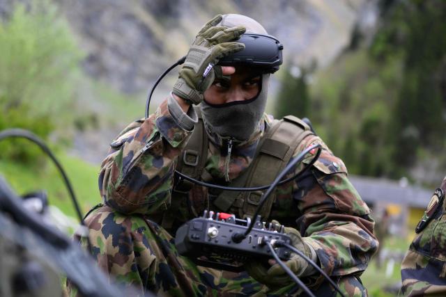 A Swiss soldier holds an FPV drone during a demonstration of procedures for deploying mini-drones in combat situations by the Swiss Army's Drones and Robotics Defence Competence Centre at the Wichlen shooting range near Glarus-Sud on May 18, 2026. (Photo by HAROLD CUNNINGHAM / AFP)