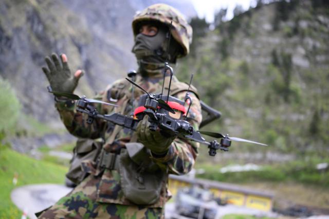 A Swiss soldier holds an FPV drone during a demonstration of procedures for deploying mini-drones in combat situations by the Swiss Army's Drones and Robotics Defence Competence Centre at the Wichlen shooting range near Glarus-Sud on May 18, 2026. (Photo by HAROLD CUNNINGHAM / AFP)