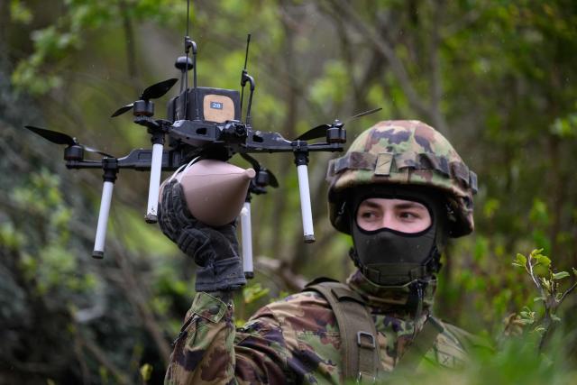 A Swiss soldier holds an FPV drone during a demonstration of procedures for deploying mini-drones in combat situations by the Swiss Army's Drones and Robotics Defence Competence Centre at the Wichlen shooting range near Glarus-Sud on May 18, 2026. (Photo by HAROLD CUNNINGHAM / AFP)