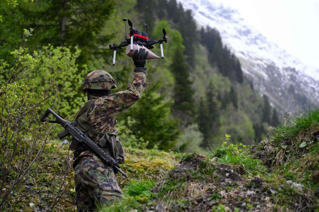 A Swiss soldier holds an FPV drone during a demonstration of procedures for deploying mini-drones in combat situations by the Swiss Army's Drones and Robotics Defence Competence Centre at the Wichlen shooting range near Glarus-Sud on May 18, 2026. (Photo by HAROLD CUNNINGHAM / AFP)