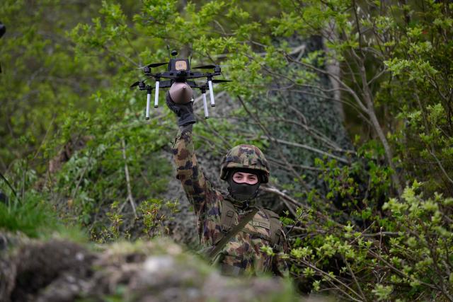 A Swiss soldier holds an FPV drone during a demonstration of procedures for deploying mini-drones in combat situations by the Swiss Army's Drones and Robotics Defence Competence Centre at the Wichlen shooting range near Glarus-Sud on May 18, 2026. (Photo by HAROLD CUNNINGHAM / AFP)